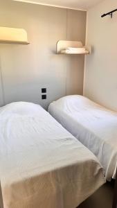 two beds sitting next to each other in a room at Camping Villa Park Zambujeira do Mar in Zambujeira do Mar