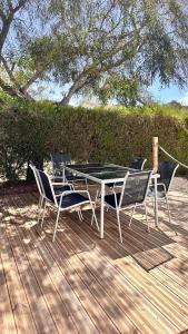 a table and chairs on a wooden deck at Camping Villa Park Zambujeira do Mar in Zambujeira do Mar