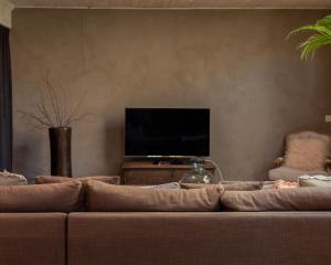 a living room with a couch and a flat screen tv at Private Loft with Hammam & Terrace near Ghent in Sint-Martens-Latem