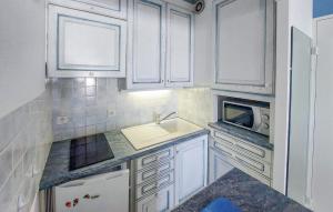 a kitchen with white cabinets and a sink and a microwave at Cozy Apartment In Saint Gilles Croix De in Le Sablais