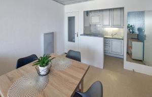 a dining room table with a potted plant on top of it at Cozy Apartment In Saint Gilles Croix De in Le Sablais