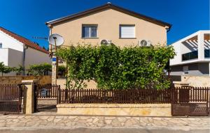 a house with a fence and a tree at Lovely Apartment In Gornji Karin in Gornji Karin