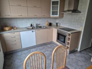 cocina con fregadero, fogones y 2 sillas en Kirkkonummi Rock, en Pikkala