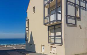 a white building with windows overlooking the ocean at Lovely Apartment In Ambleteuse in Ambleteuse