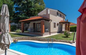 una casa e una piscina di fronte a una casa di Villa Orchidea a Višnjan (Visignano)