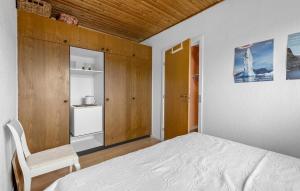 a bedroom with a bed and a chair at Cozy Home In Årslev With Wifi in Årslev