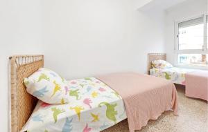a bedroom with a bed and a blanket with dinosaurs on it at 2 Bedroom Amazing Apartment In Cullera in Cullera +6 photos