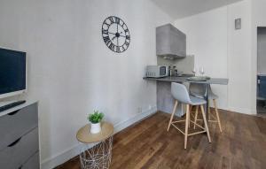 a kitchen with a counter and a clock on the wall at Stunning Apartment In Saint-Malo in Saint Malo