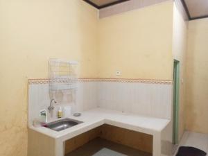a bathroom with a sink in a room at Penginapan Syari'ah Parak Anau in Tabing