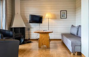 a living room with a couch and a table with a tv at 2 Bedroom Stunning Home In Degeberga in Degeberga