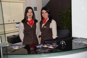 dos mujeres están de pie junto a una mesa en Hotel Elegance, en Sarajevo