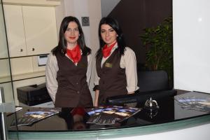 two women are standing next to a table at Hotel Elegance in Sarajevo