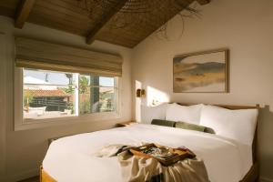 a bedroom with a large white bed with a window at Woods Cove Inn in Laguna Beach +44 photos
