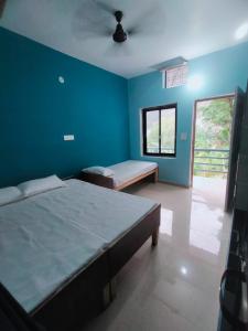 a bedroom with two beds and a blue wall at Mountain Berry Cafe and Homestay in Chutwāpīpal