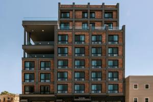 a tall brick building with windows at Sonder by Marriott Bonvoy The Dutch Apartments Long Island City in Long Island City