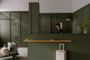 a person in a mirror in a green room with luggage at Sonder by Marriott Bonvoy The Dutch Apartments Long Island City in Long Island City