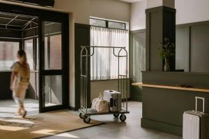 a woman walking through a lobby with a luggage cart at Sonder by Marriott Bonvoy The Dutch Apartments Long Island City in Long Island City +33 photos