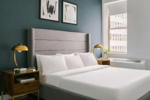 a bedroom with a white bed and a blue wall at Nester Finn Financial District in New York