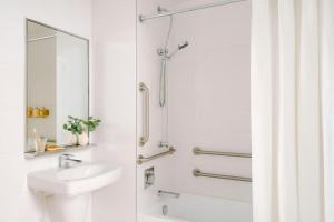 a white bathroom with a shower and a sink at Nester Finn Financial District in New York +38 photos