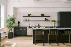 a kitchen with black cabinets and a kitchen island at Nester Finn Financial District in New York