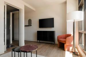 シアトルにあるSonder by Marriott Bonvoy Pivot Apartments Capitol Hillのリビングルーム(テレビ、椅子付)