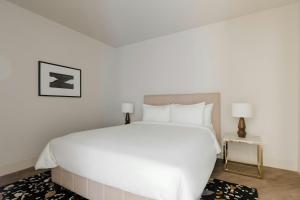 シアトルにあるSonder by Marriott Bonvoy Pivot Apartments Capitol Hillのベッドルーム(大きな白いベッド1台、ランプ2つ付)