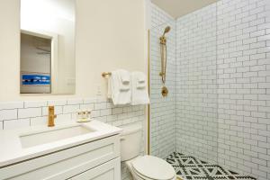 a white bathroom with a toilet and a sink at The Louie Hotel New Orleans, Belvilla District 6 Formerly Sonder in New Orleans