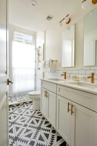 a bathroom with a black and white tile floor at The Louie Hotel New Orleans, Belvilla District 6 Formerly Sonder in New Orleans