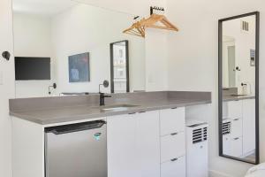 a white bathroom with a sink and a mirror at The Boylston Hotel Capitol Hill in Seattle +48 photos