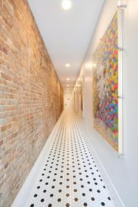 新奥尔良Sonder by Marriott Bonvoy The Vitascope Apartments French Quarter的空荡荡的走廊，有砖墙和艺术品
