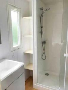 a white bathroom with a shower and a sink at Camping 3 étoiles - eed0ca in Priziac +60 photos