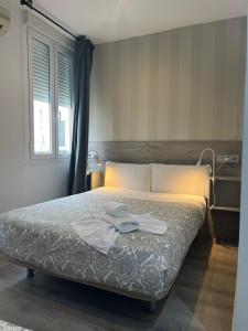 Łóżko lub łóżka w pokoju w obiekcie Hostal Abril Madrid