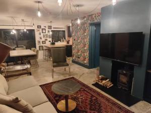 a living room with a couch and a fireplace at Cotswold Stay in Burford