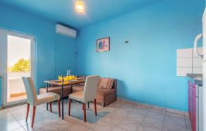a dining room with blue walls and a table and chairs at Amazing Apartment In Povljana With Wifi in Povljana