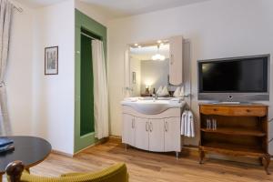 un soggiorno con una televisione e un lavandino bianco di Hotel Austria a Bad Hofgastein