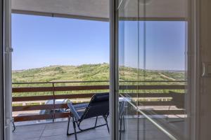 a chair on a balcony with a view of a hill at Neda Apartment In Krasno Among Vineyard - Happy Rentals in Šmartno