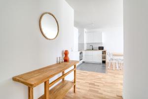 a kitchen and living room with a wooden table and a mirror at Home Sweet Home in Bezons +9 photos