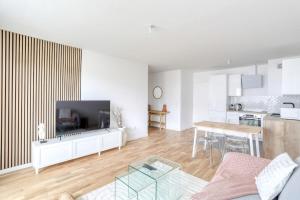 a living room with a couch and a table and a kitchen at Home Sweet Home in Bezons