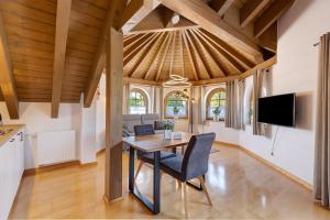 a dining room with a table and a tv at Haus Ella in Königsfeld im Schwarzwald