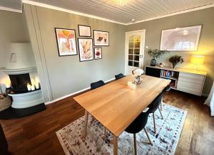 a dining room with a wooden table and a fireplace at Anchor Point Farsund in Farsund