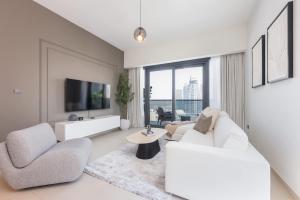 un soggiorno con mobili bianchi e una grande finestra di Top Class 2BR with Burj Khalifa View in Downtown a Dubai