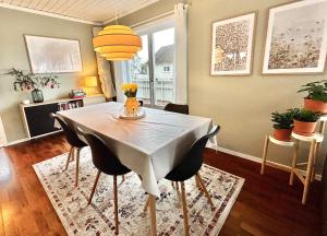 a dining room with a white table and chairs at Anchor Point Farsund in Farsund