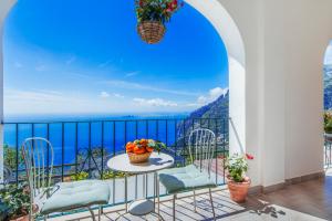 d'un balcon avec une table et des chaises donnant sur l'océan. dans l'établissement L'Uliveto, à Positano