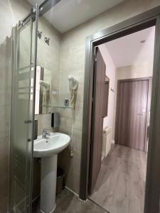 łazienka z umywalką i przeszkloną kabiną prysznicową w obiekcie Hostal Abril Madrid w Madrycie