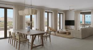 a dining room with a table and chairs and a couch at Parilio, a Member of Design Hotels in Naousa