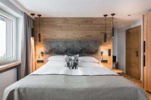 a bedroom with a large bed with wooden walls at Natur- & Genießerhotel Der Birkenhof in Oberstaufen +79 photos