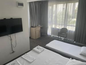 a hotel room with two beds and a flat screen tv at HOTEL Vitan273 in Bucharest
