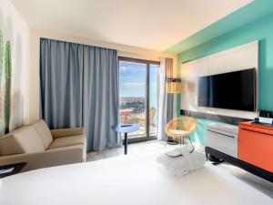 a hotel room with a bed and a large window at Novotel Monte-Carlo in Monte Carlo