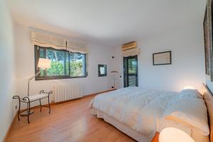 Un dormitorio con una cama y una mesa y una ventana. en Casa Montalt, en Sant Vicenç de Montalt