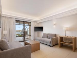 a living room with a couch and a chair at Porto Platanias Beach Resort & Spa in Plataniás